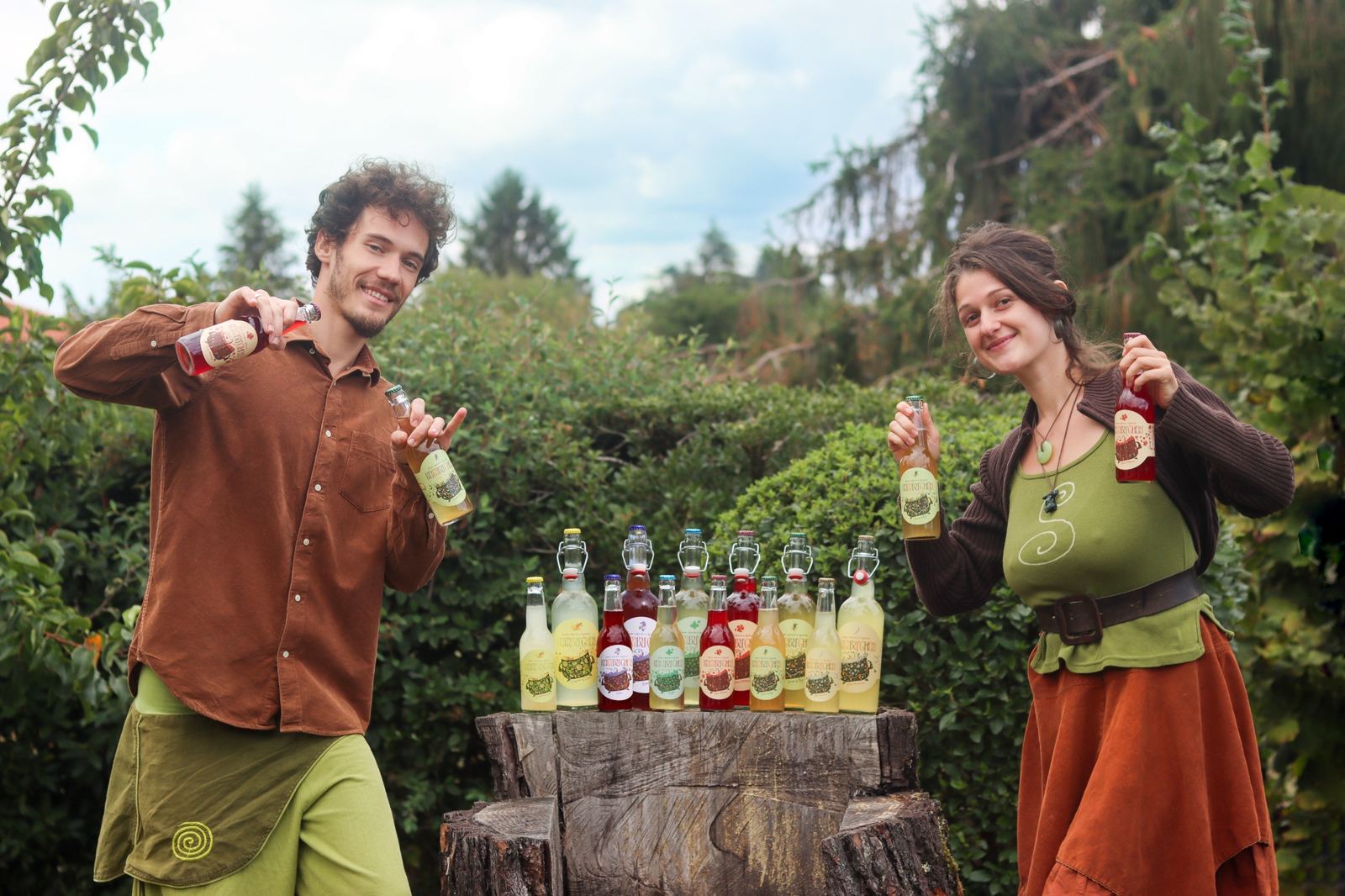 Désiré et Cassandre dans leur jardin, bouteilles de Kombuchou en main